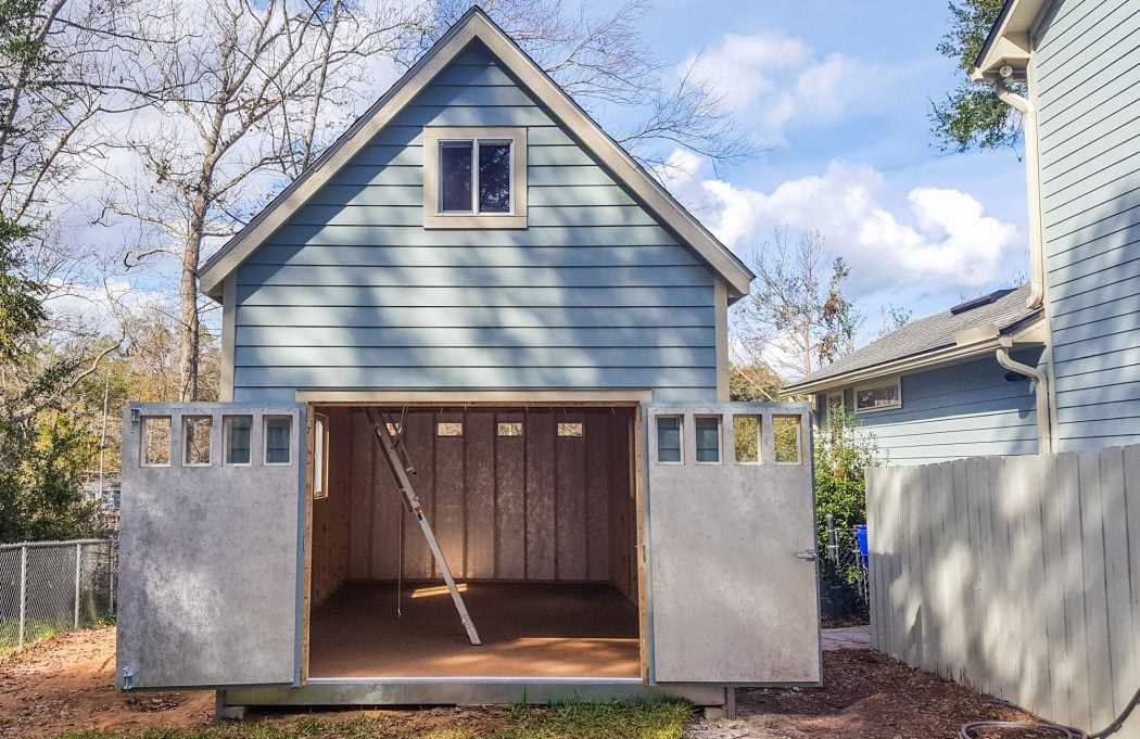Big and Tall blue Tuff Shed building with the shed doors open and a ladder