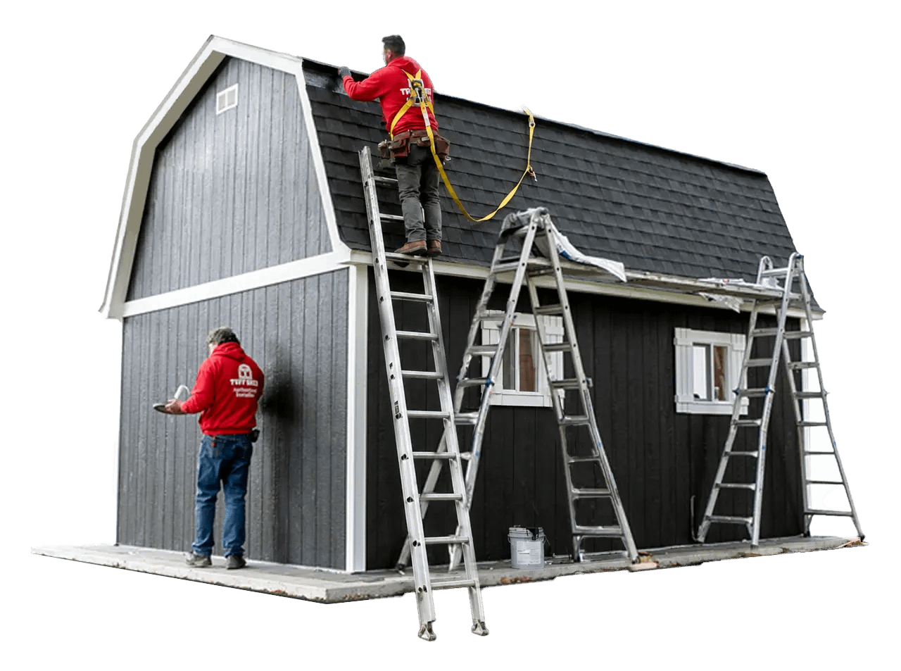 Two workers in red hoodies construct a dark gray building with ladders. One stands on a ladder, while the other works below.