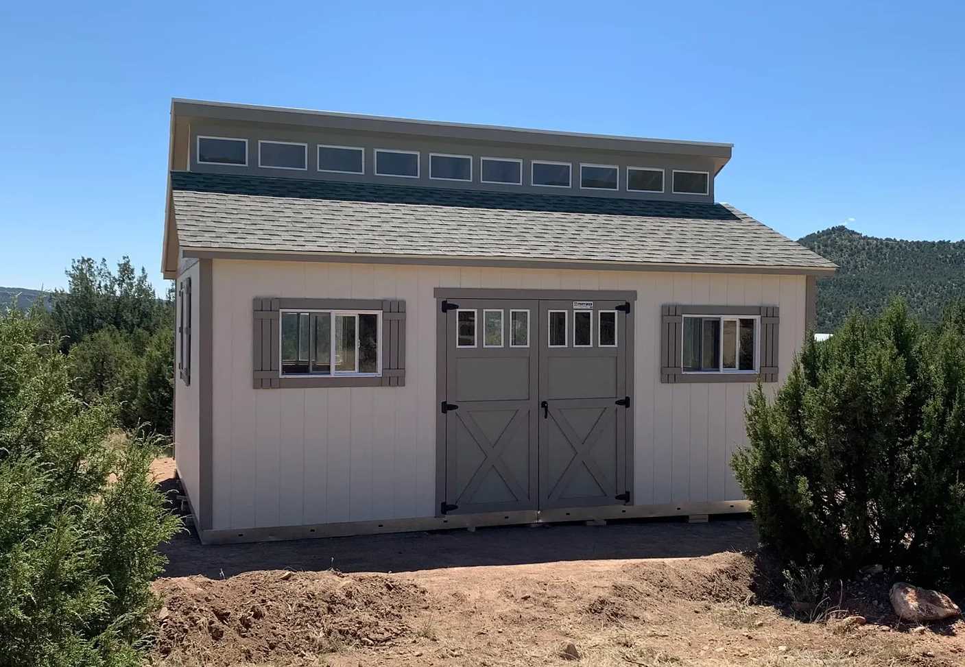 Light brown and grey shed with a clerestory in a desert feild