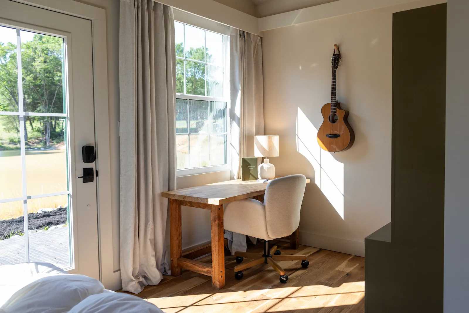 Richard Casteel Interior of Premier Tall Ranch turned into a cabin with a desk and a guitar on the wall