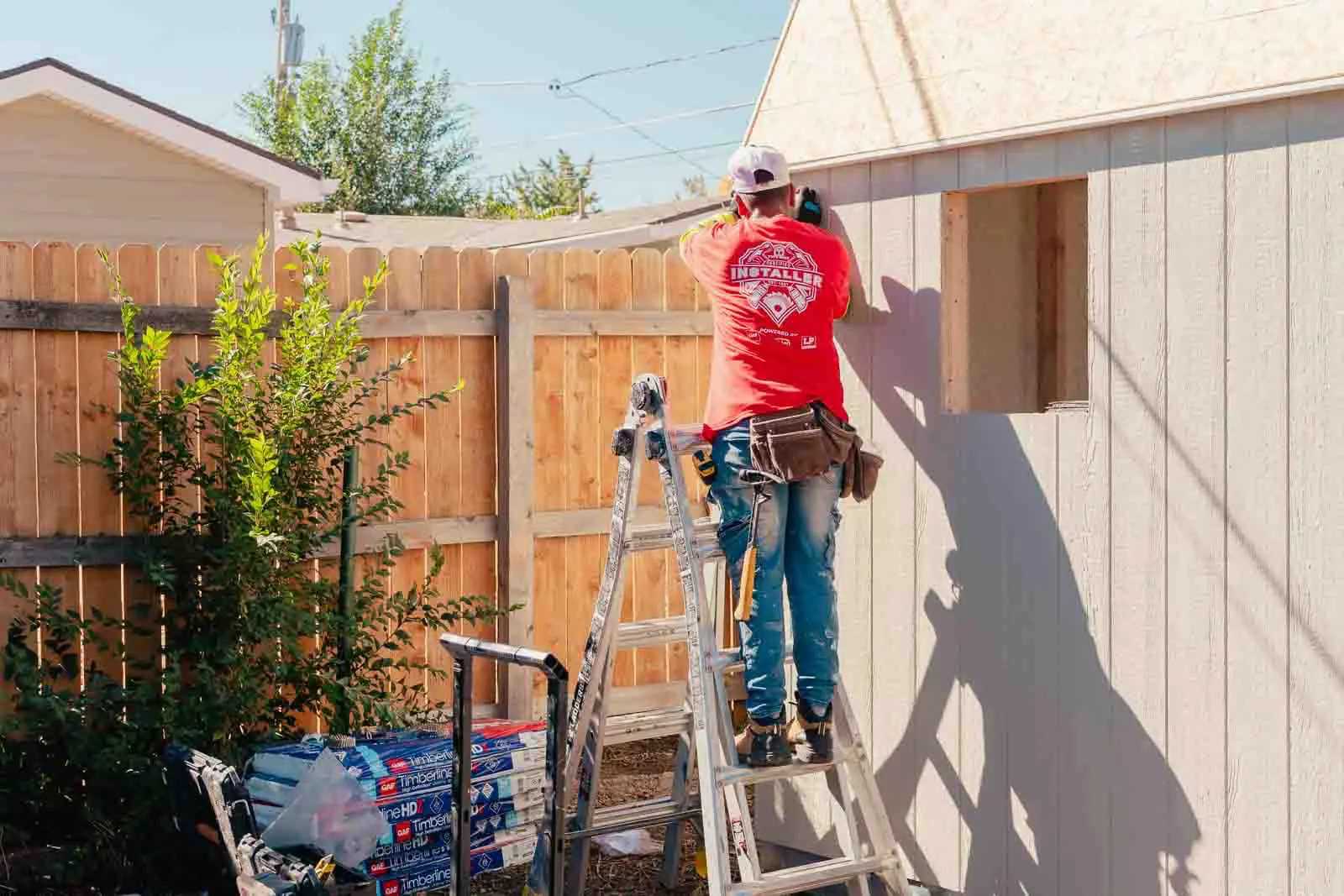 Premier Tall Barn with installer working on a ladder