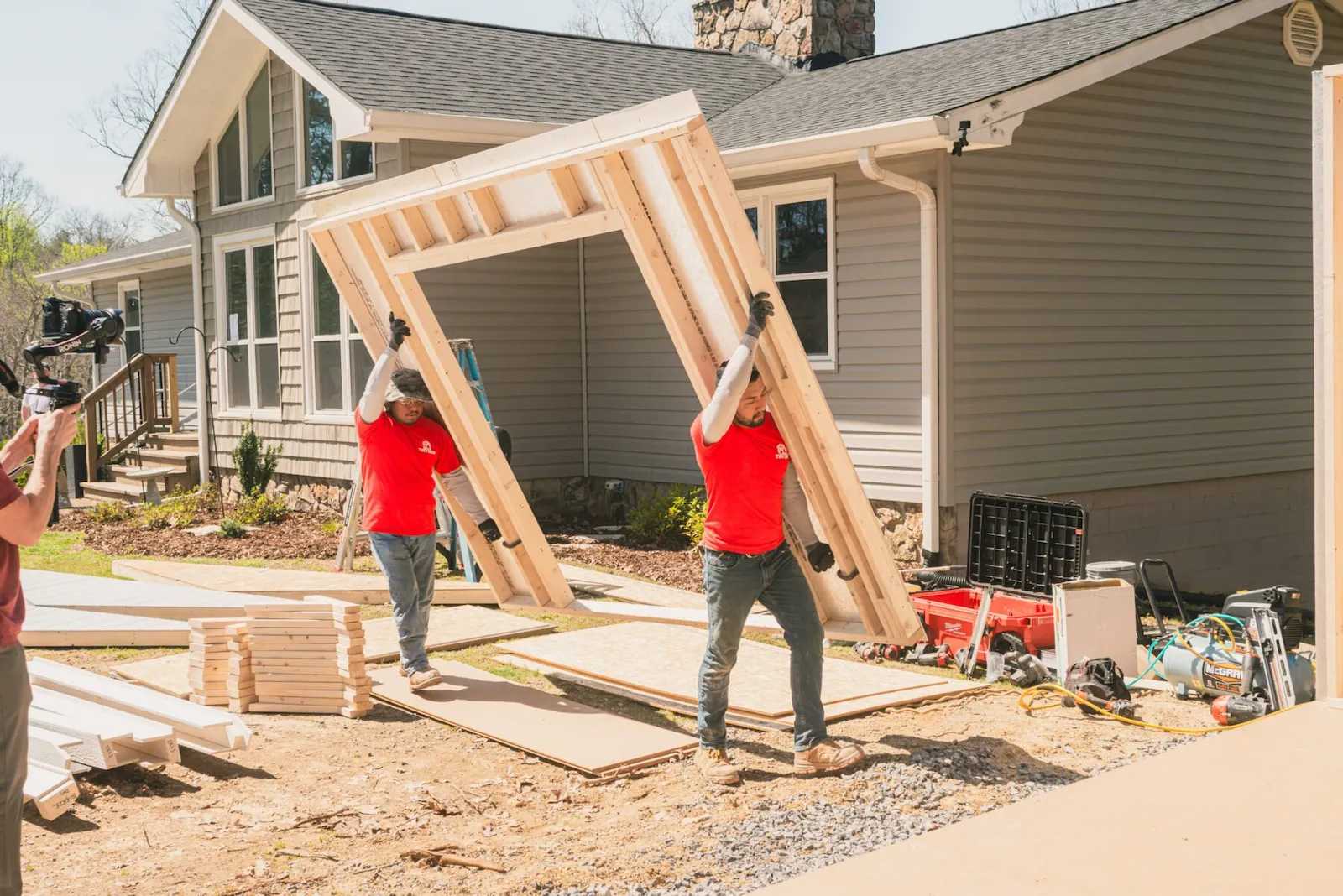Installers carrying a wall for a shed