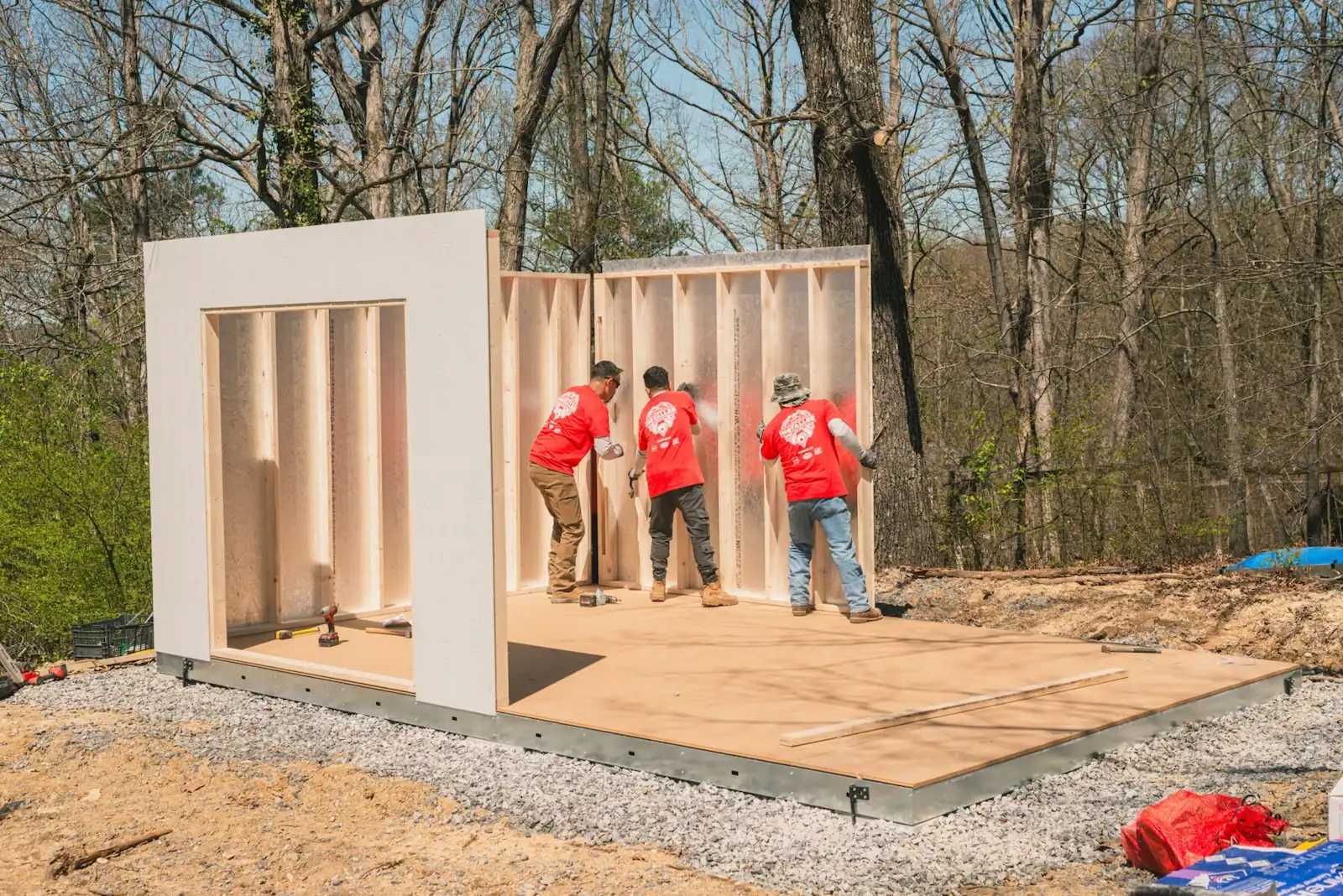 Installers putting up walls of a shed