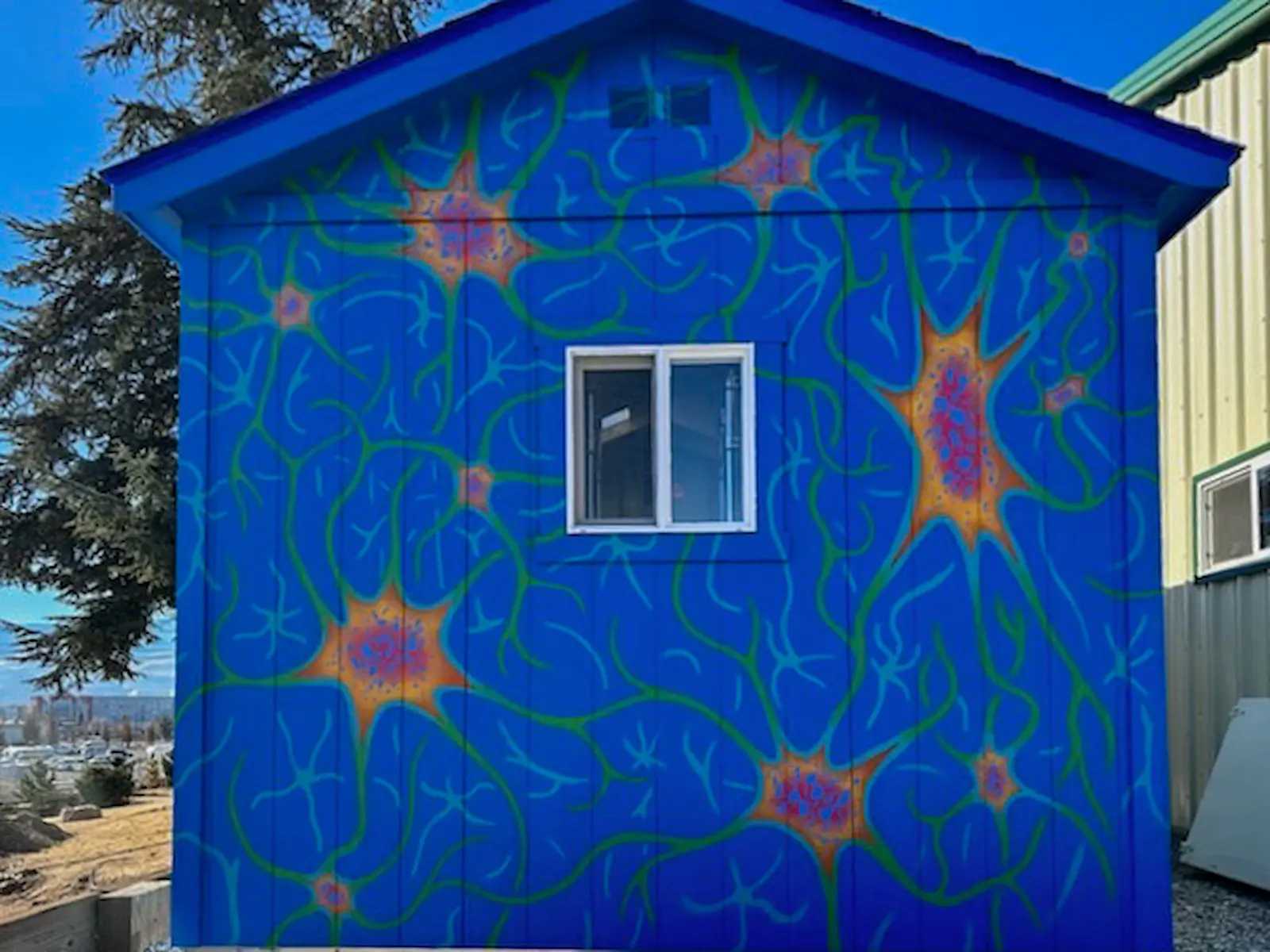Bright blue barn with a painted mural
