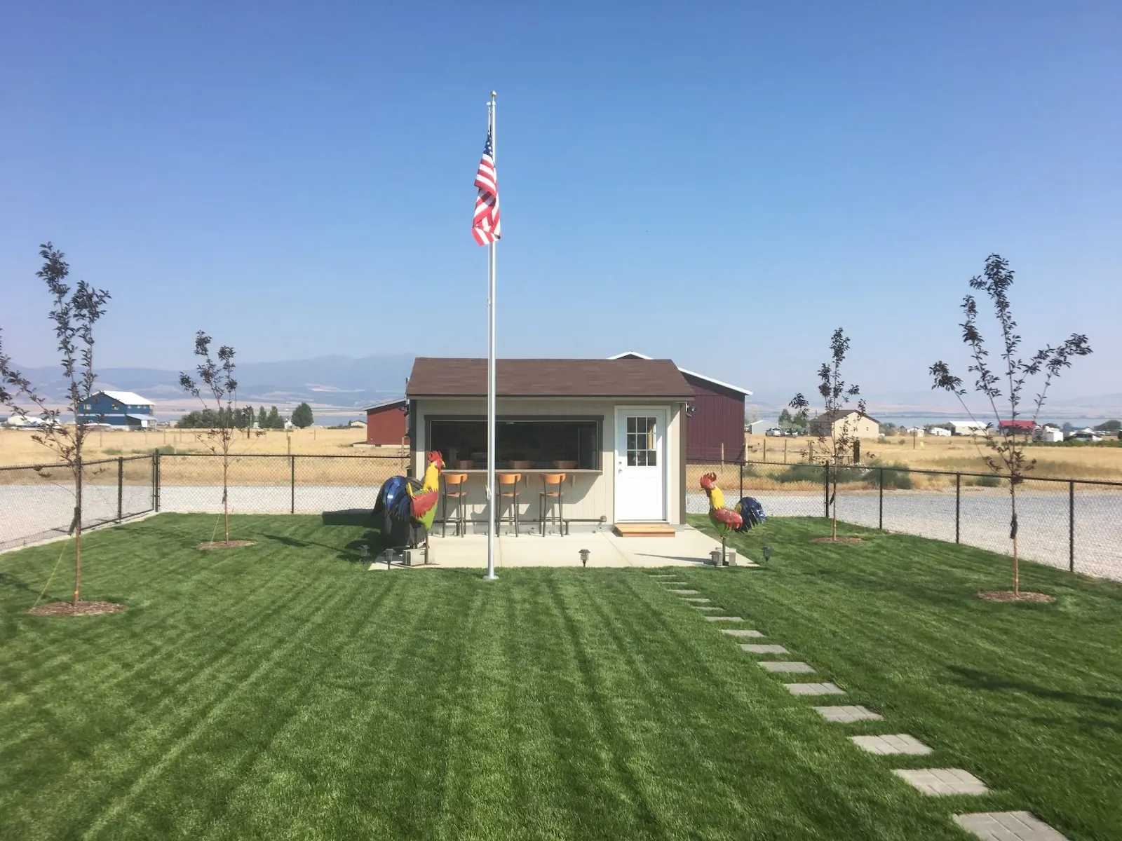 Exterior of premier tall ranch shed with a bar and flagpole out front