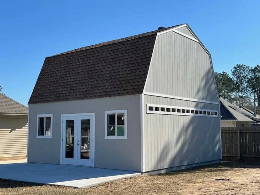 Large gray Premier Barn Garage on a concrete pad in a backyard