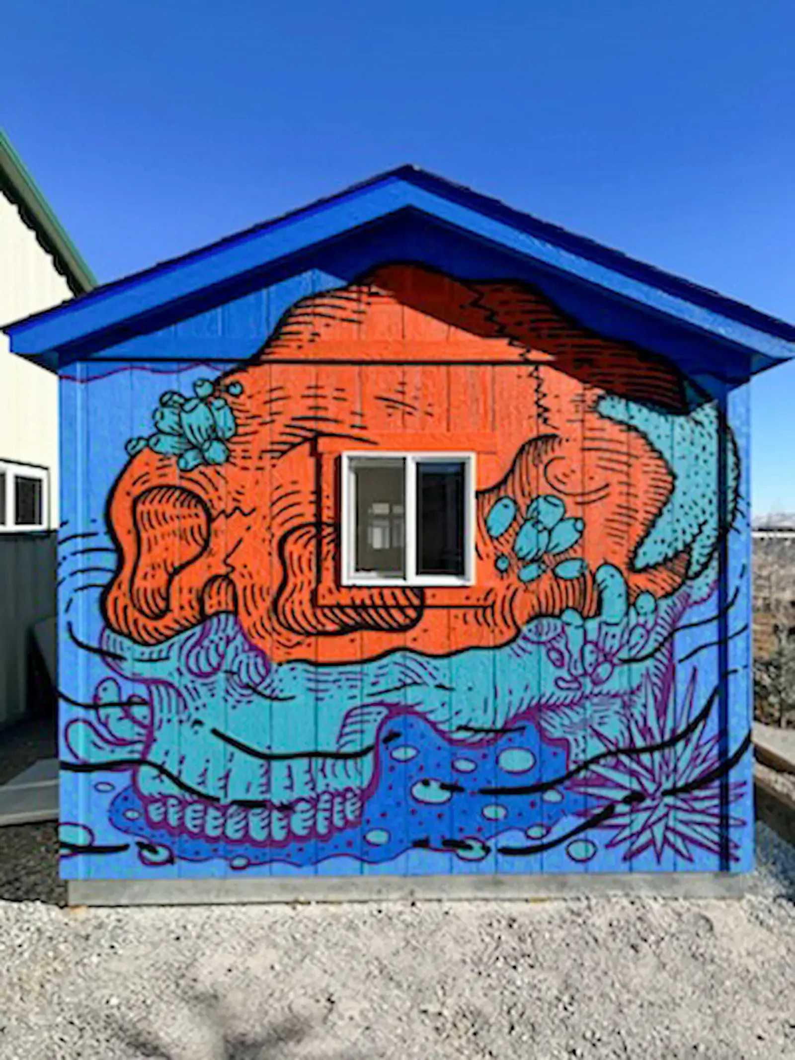 Bright blue building with a colorful mural