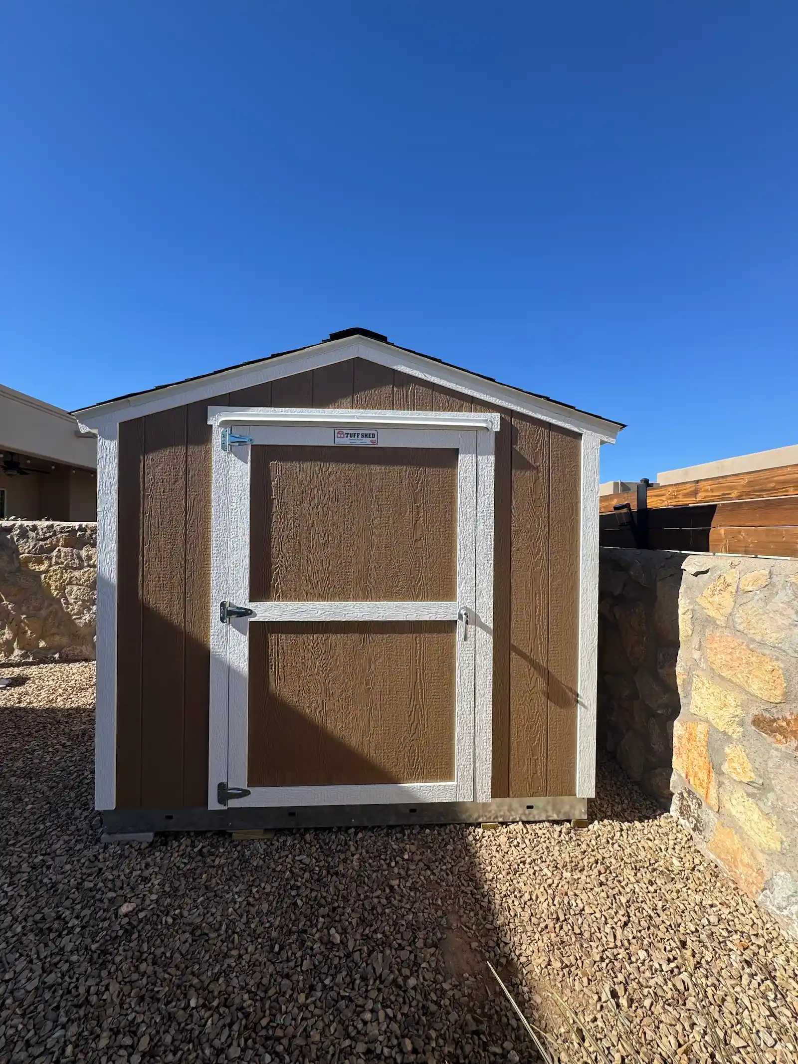 Brown Premier Standard Ranch in a backyard near a stone wall