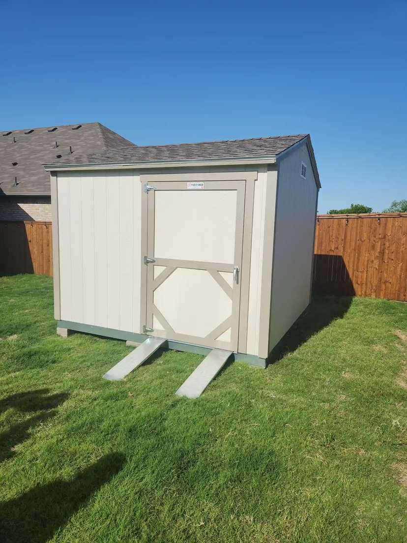 Premier Ranch building in a backyard with grass and a wood fence