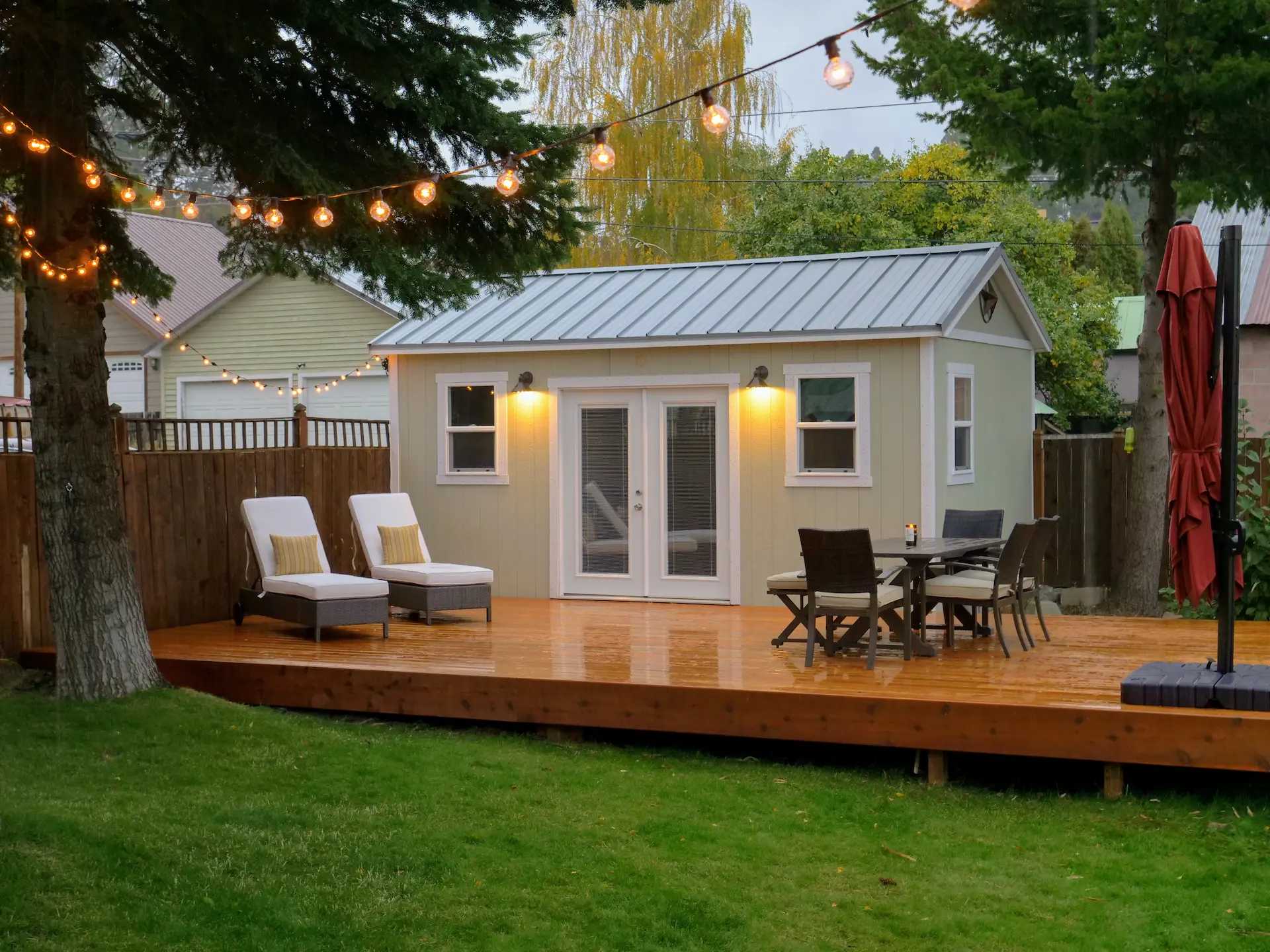 Tall ranch building on deck with glass doors and windows in backyard
