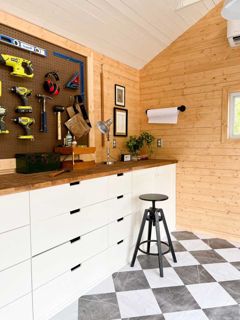 Interior of Premier Pro Tall Ranch workshop with workbench and stool and tools