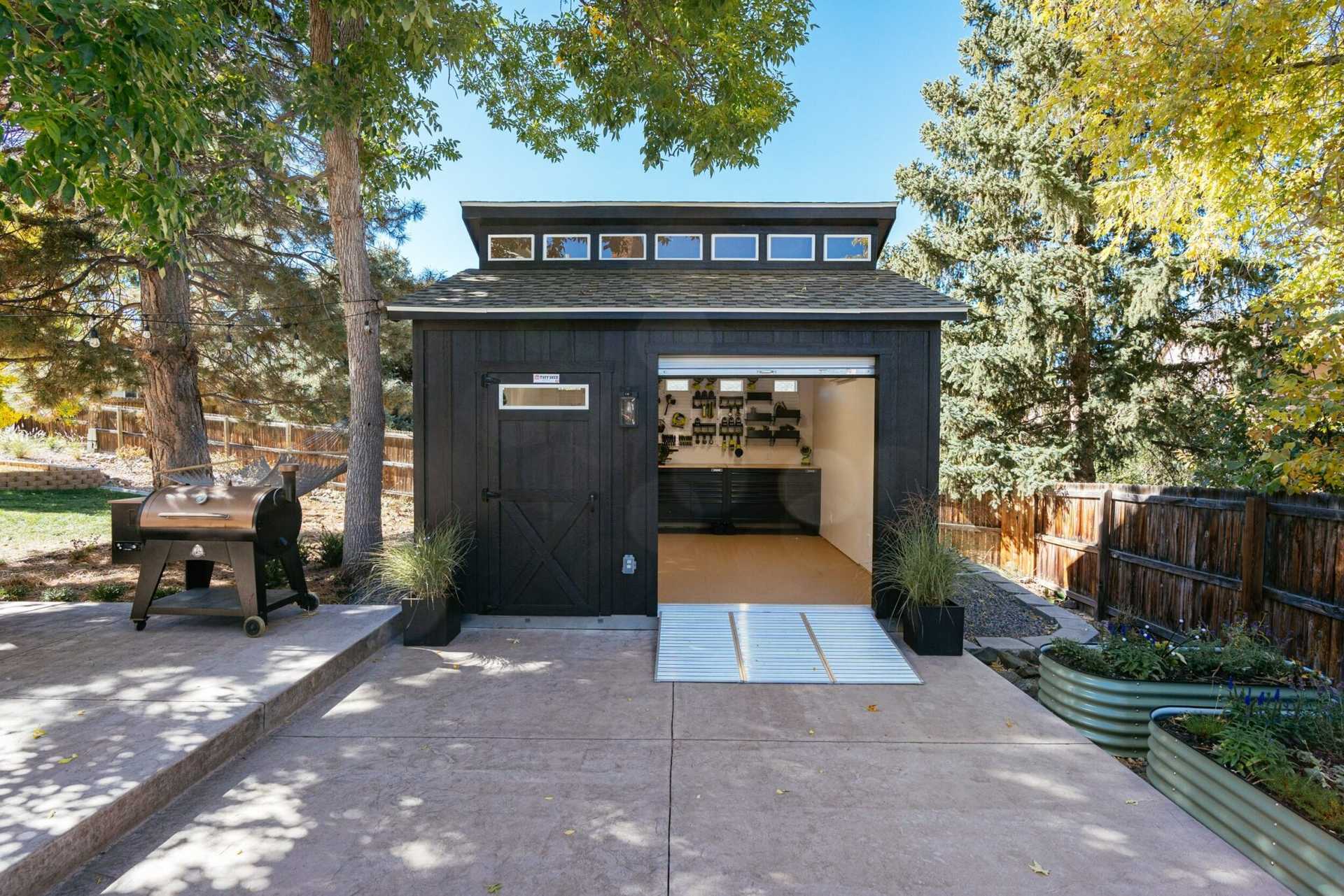 Big black shed with tool storage inside.
