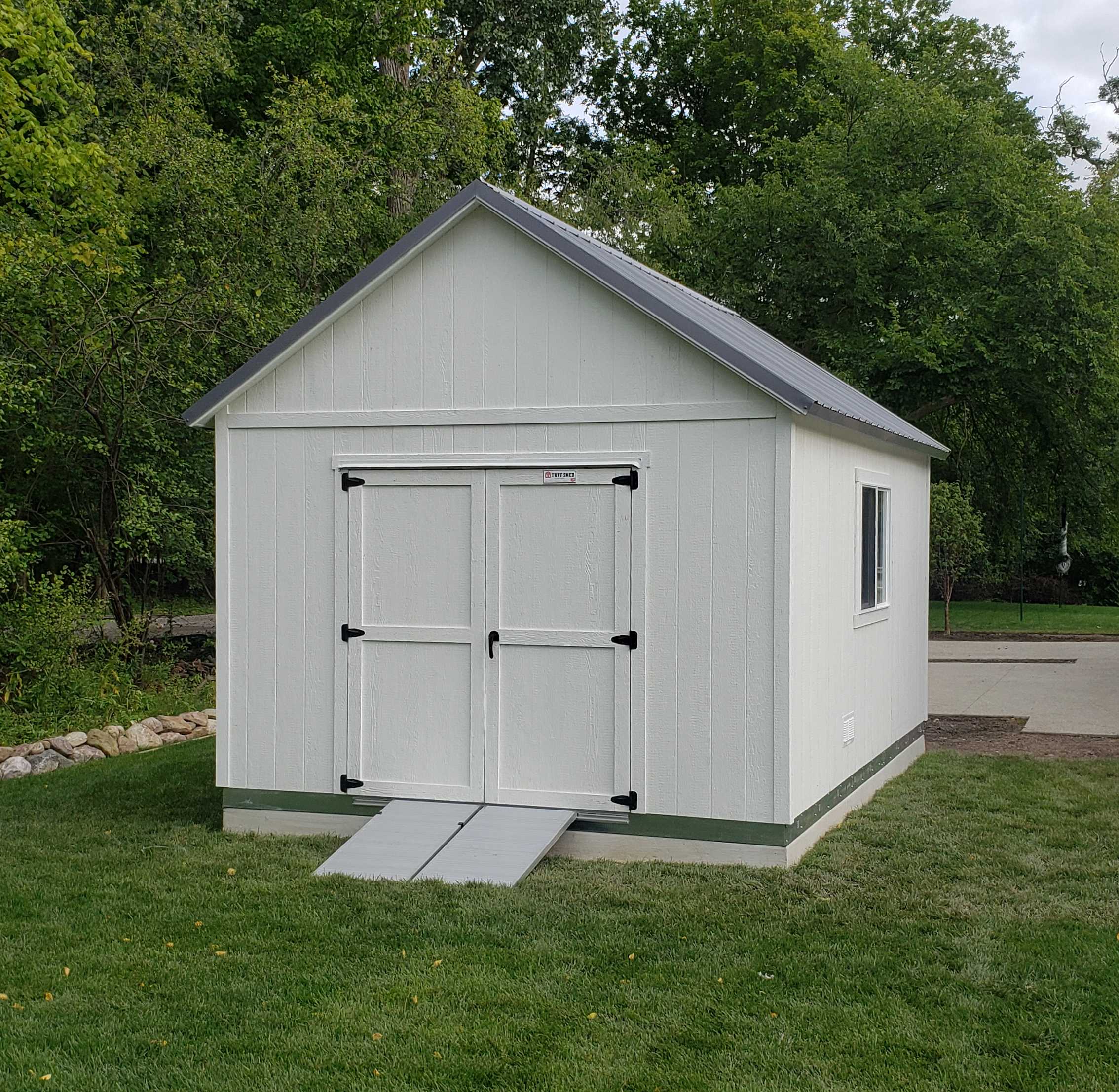 A premier tall ranch in a backyard meant for storage of tools and vehicles that can also be for a guest space.