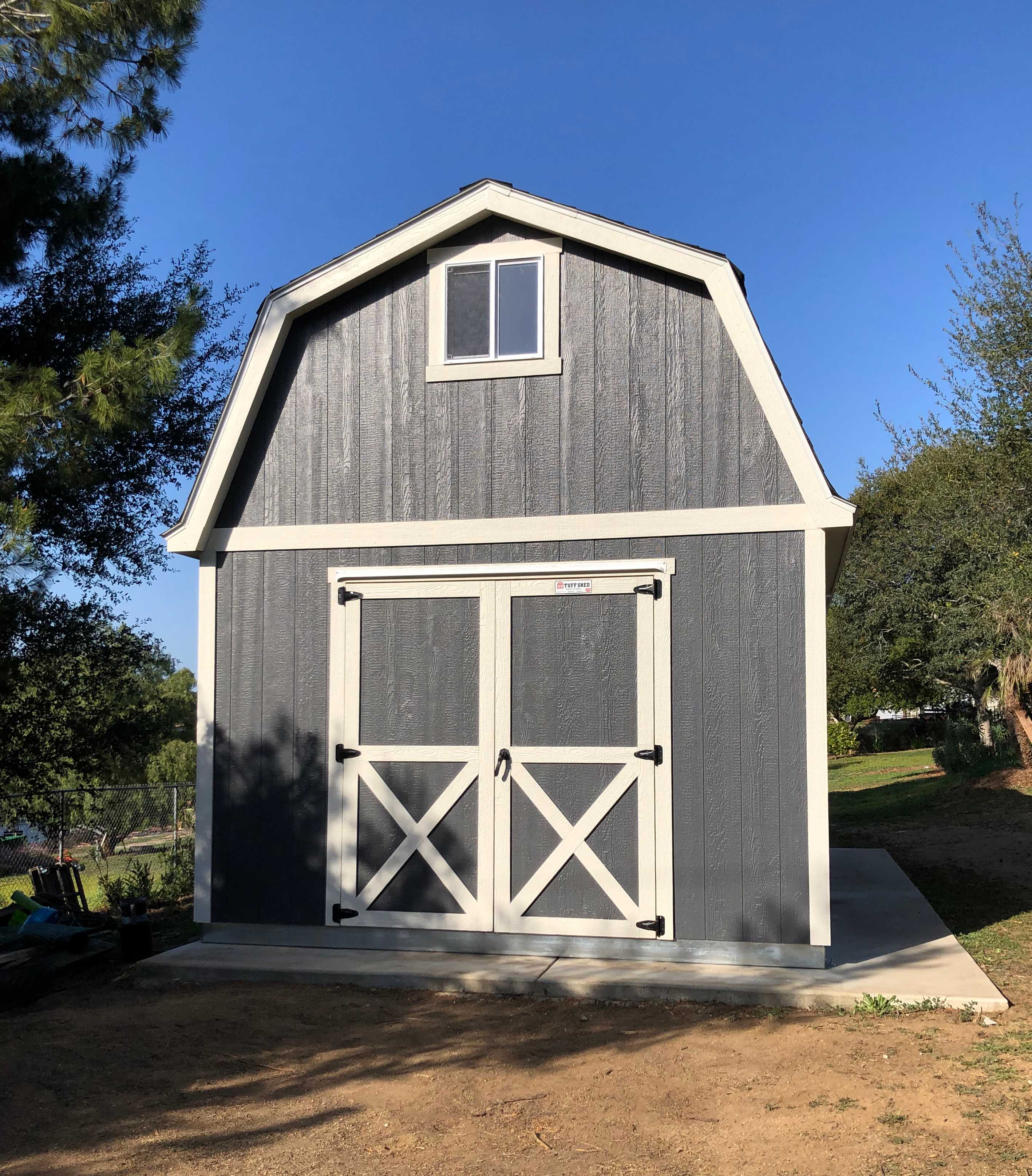 grey and white barn in a backyard