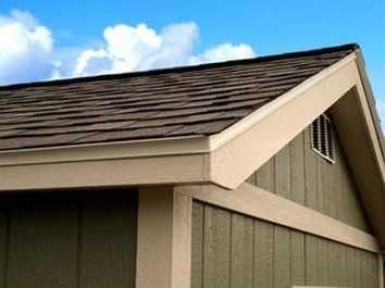 exterior picture of the top of a tuff shed roof with a blue sky and white cloud behind it