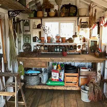 potting work station with art and dry plants hanging on the wall