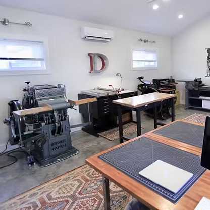 interior image of the print studio with tables and letterpress