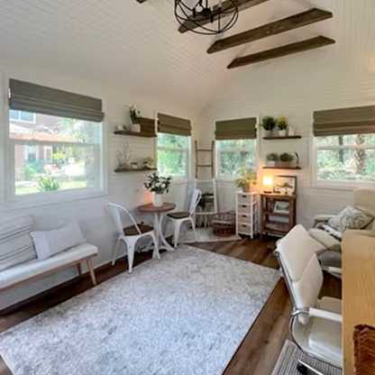 a bright white cozy office and a bistro table, desk and a bench by the window