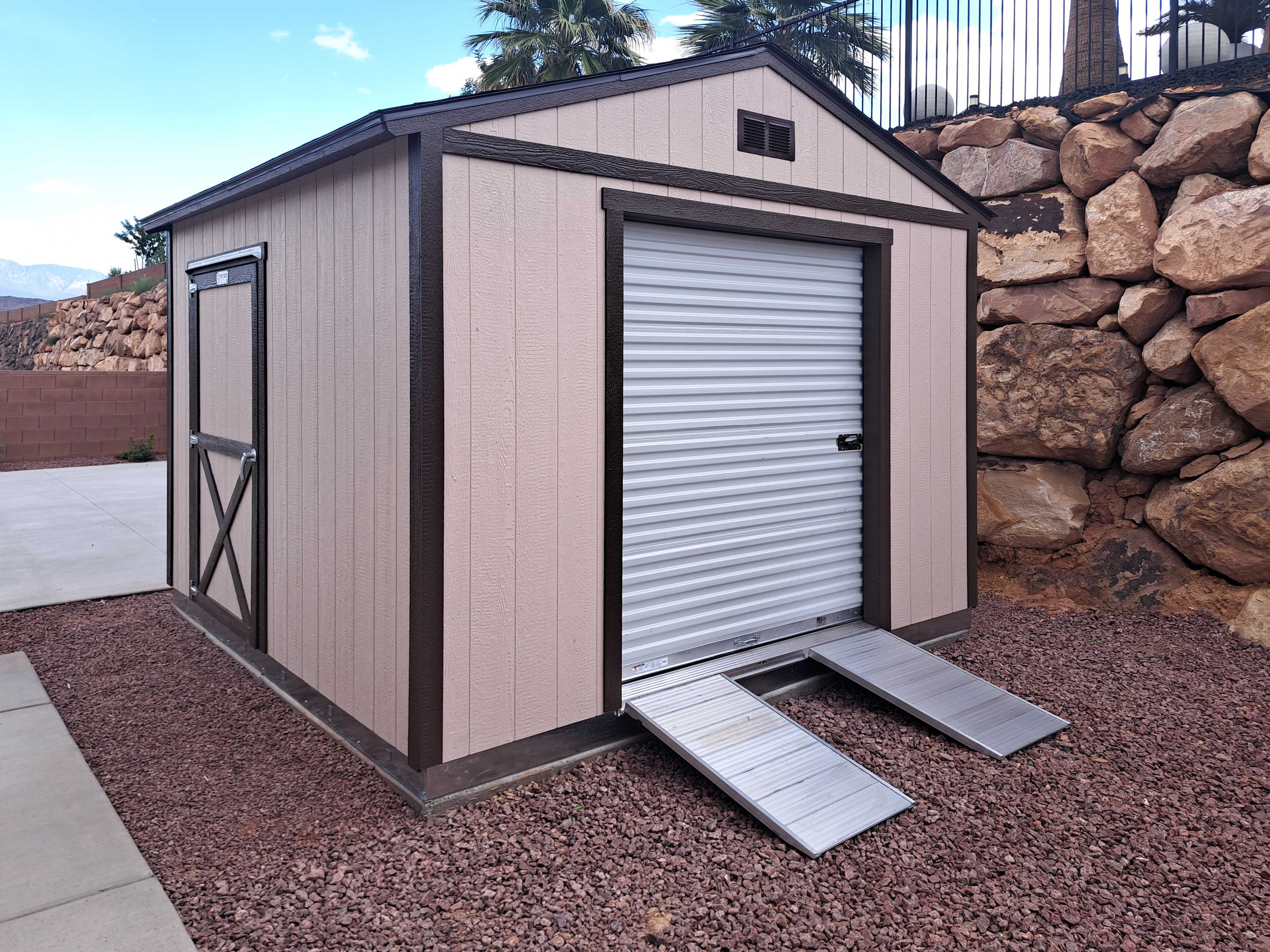 A premier tall ranch in a backyard meant for storage of tools and vehicles that can also be for a guest space.