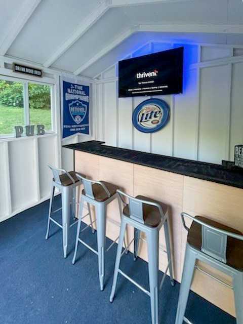 A premier tall ranch with a bar top and chairs and a TV.