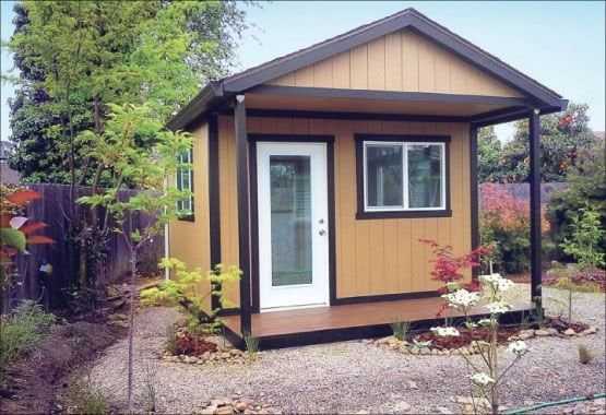 Premier PRO Ranch Weekender Brown with White Door on gravel yard in backyard