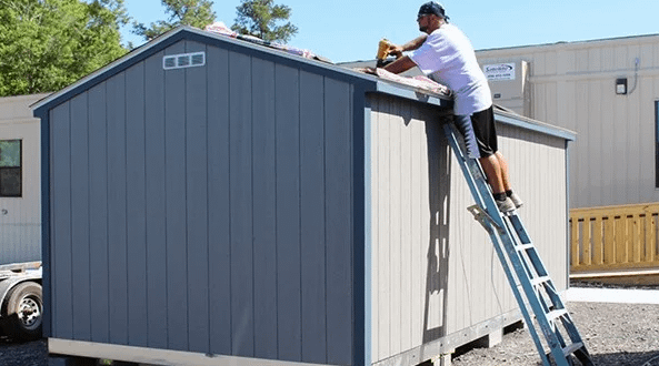 Exterior of South Side Elementary Shed Prize with installer on ladder behind