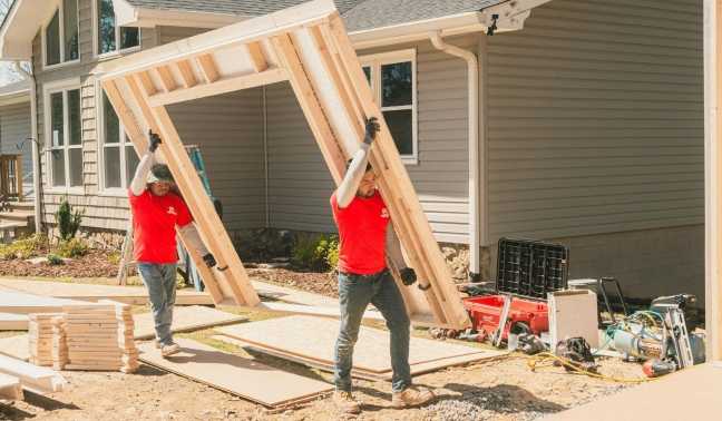 Installers carrying wall panel