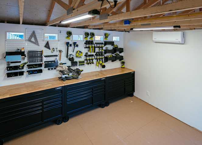 Interior of Premier Pro Ranch Garage workshop with tools on the wall and workbenches