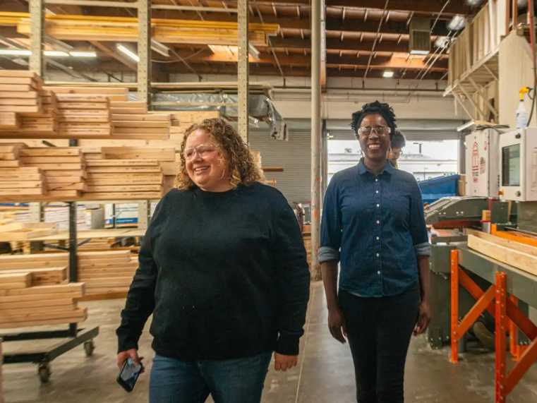 Two women walking through the factory